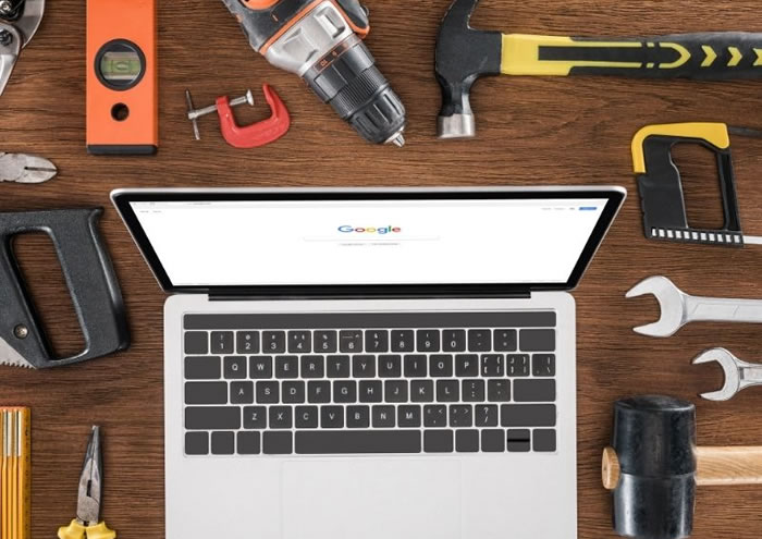 Laptop on desk surrounded by tools